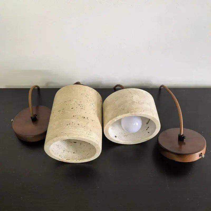 Two beige stone shade pendant lights with copper bases and braided cords for kitchen or dining room ceiling tray lighting