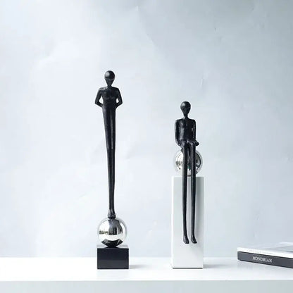 Two minimalist black metal figurines with elongated limbs on reflective spheres for abstract thinker decorbites living room decor