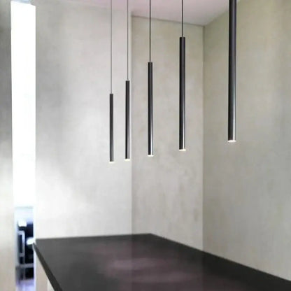 Five sleek black aluminum led ceiling track spotlights emit a soft glow in a minimalist kitchen setting