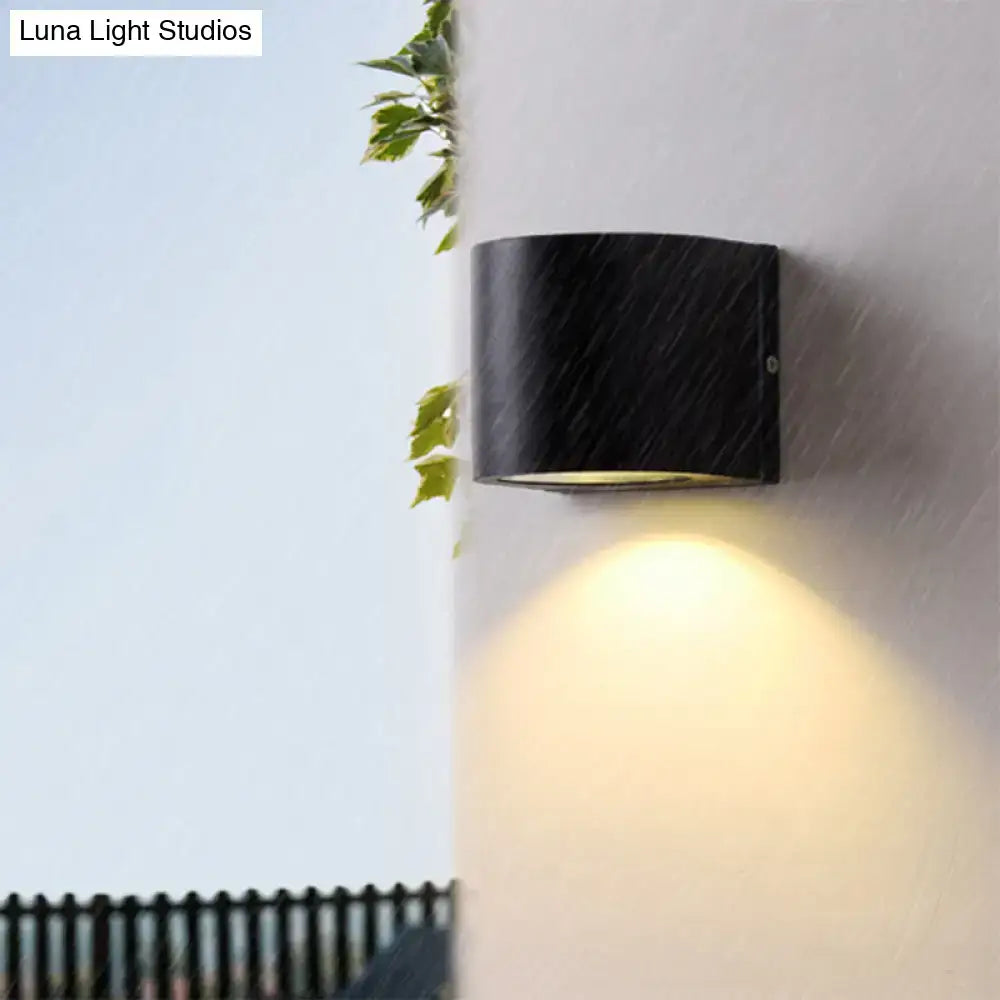 Minimalist black aluminum outdoor cylinder wall light with matte finish and warm focused light for direct wired electric outdoor space
