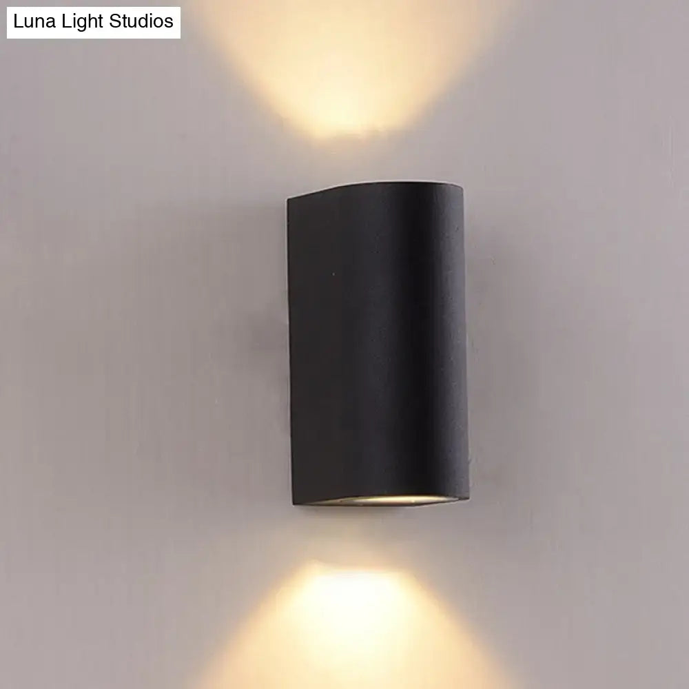 Minimalist black aluminum outdoor cylinder wall light emitting warm light top and bottom for direct wired electric outdoor space
