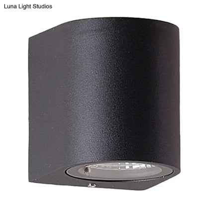 Minimalist black aluminum cylindrical wall light with matte finish and circular led direct wired electric fixture for outdoor space