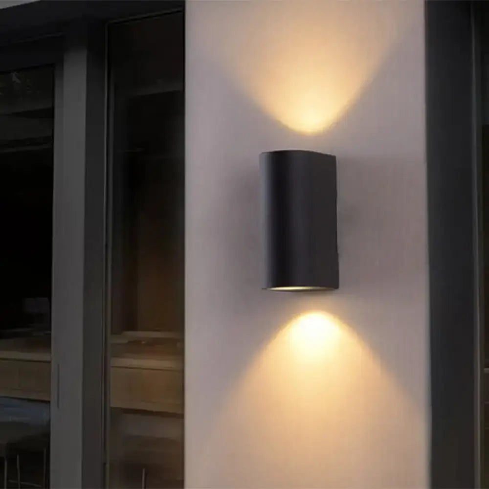 Minimalist black aluminum wall light with warm focused lighting for direct wired electric outdoor space use