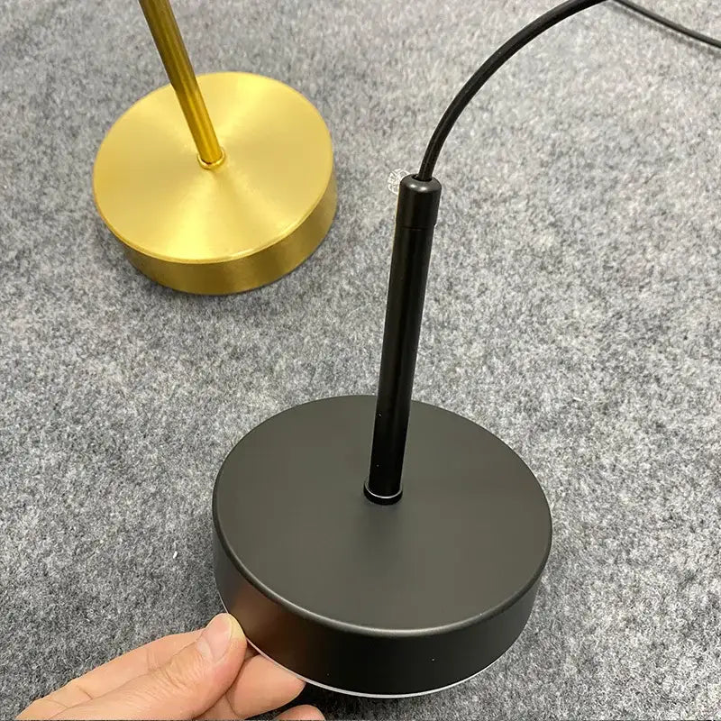 Minimalist black matte table lamp base with cylindrical stem and power cord for frosted white pendant light use