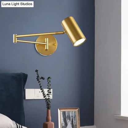 Minimalist black gold adjustable wall light with gold-finished cylindrical head and circular base for bedroom reading