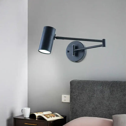 Minimalist black gold adjustable cylinder wall light with black matte finish and articulated arm for bedroom reading