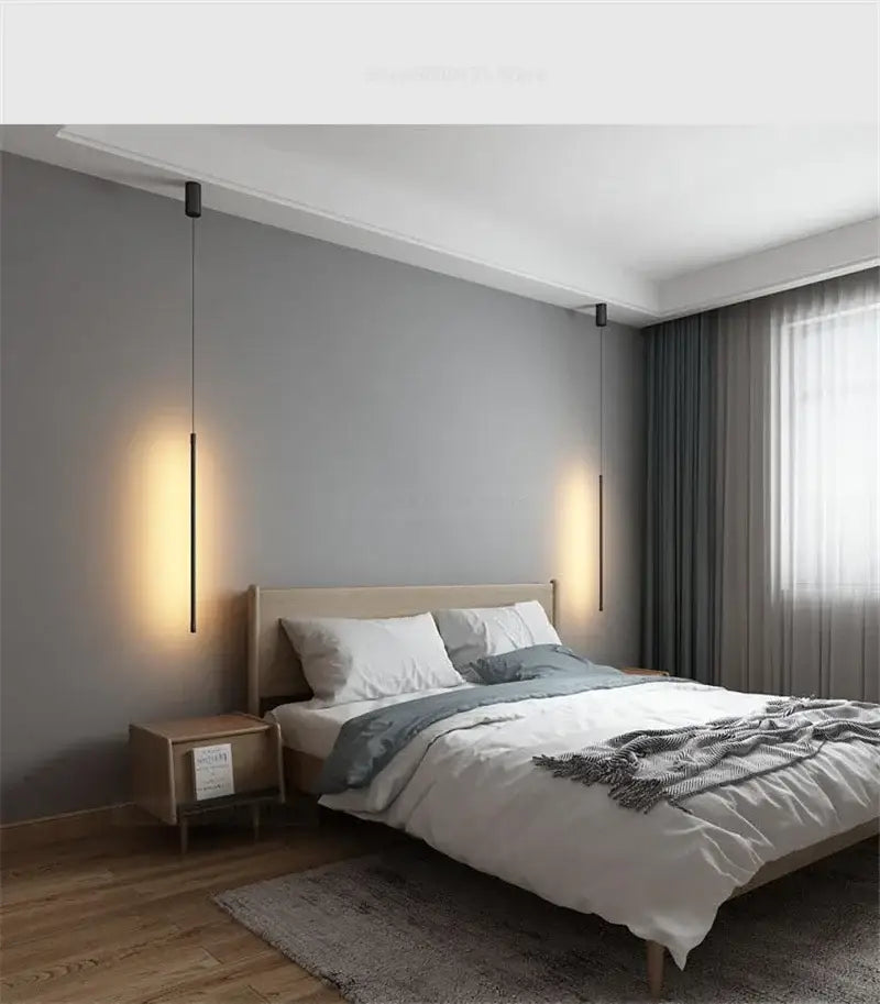 Minimalist black and white metal pendant light with slender cylindrical bodies and warm focused illumination