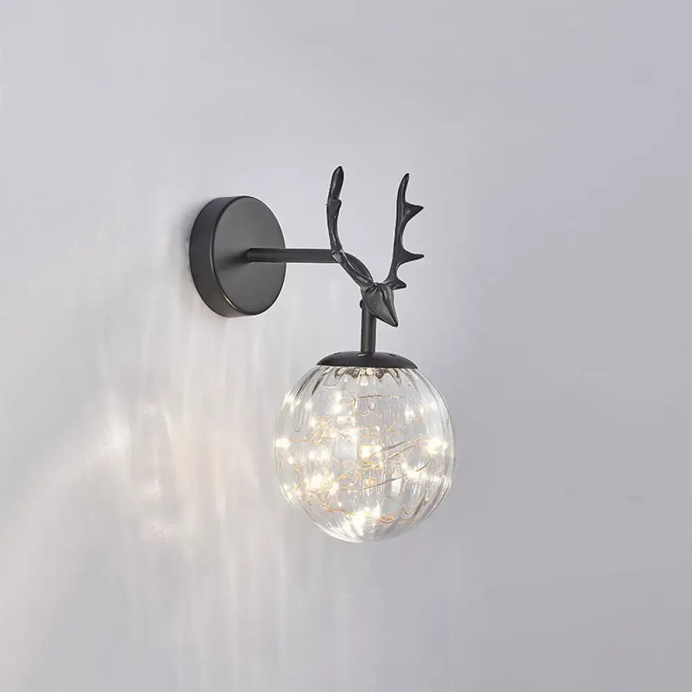 Minimalist black metal deer-head wall sconce with textured glass globe and warm fairy lights for bedroom use