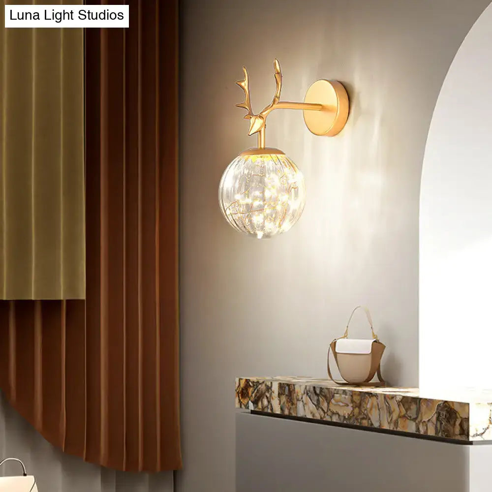 Gold-toned deer antler wall sconce with faceted crystal globe shade minimalist black antler glass globe sconce for bedroom lighting