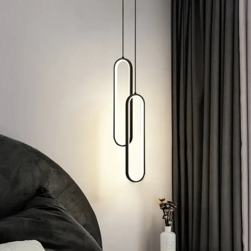 Minimalist black built-in led pendant light with two overlapping oval illuminated panels for dining table use