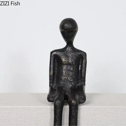 Minimalist black character metal statue of seated humanoid with matte finish, ideal as a metal statue desk ornament
