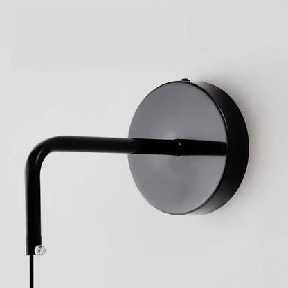 Minimalist black copper wall lamp with matte finish curved arm and circular base for sleek bedroom decorbites copper wall light
