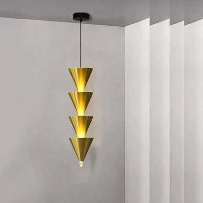 A minimalist cream bedroom chandelier with four stacked golden conical shades and a black ceiling mount by decorbites