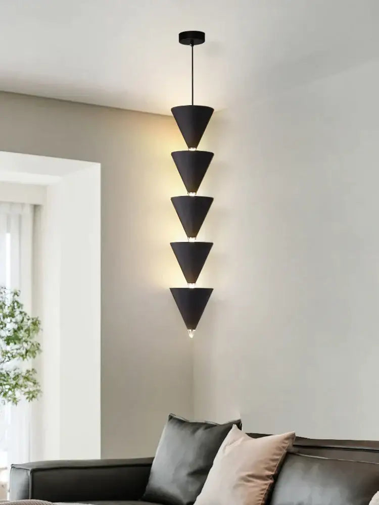 Minimalist black and cream bedroom chandelier with five stacked conical shades emitting warm ambient glow for decorbites cream bedroom decor