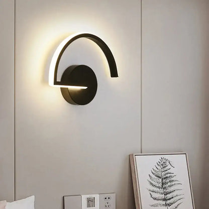 Modern black curved wall sconce with glowing white led light strip for minimalist wall mounted lighting in bedroom