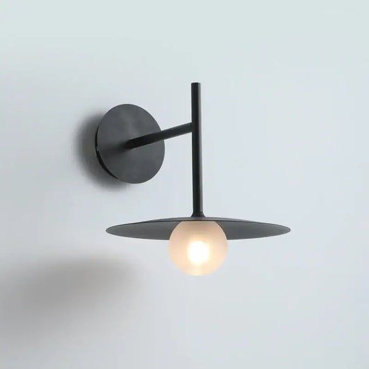 Minimalist black flying saucer wall lamp with matte finish, circular base, and frosted glass bulb for bedroom decorbites flying saucer