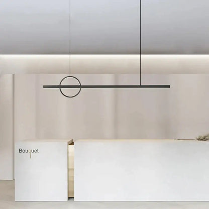 Minimalist black geometric copper chandelier pendant light with circular accent hanging above white reception desk decorbites geometric copper