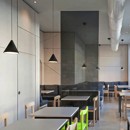 Minimalist black geometric led pendant light with sleek conical design in a modern café setting decorbites geometric led pendant