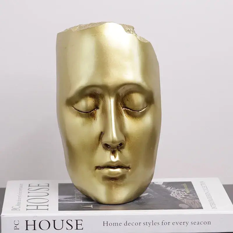 Minimalist black and gold abstract face sculpture with golden mask and smooth reflective surface for living room decor