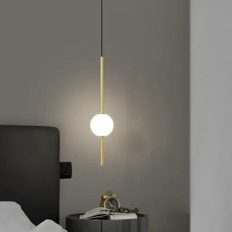 Minimalist black and gold globe pendant light with frosted glass shade and sleek metal rod for cord pendant installation