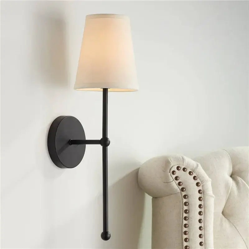 Minimalist black wrought iron led wall lamp with cream fabric shade for bedroom lighting and decor