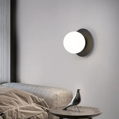 Minimalist black and gold led wall lamp with matte black base and glowing white spherical globe for living room wall lamp