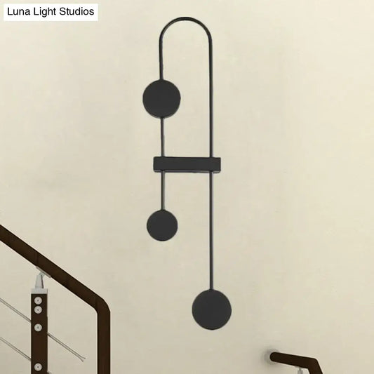 Black gold minimalist metal led wall sconce with sleek curved arms and three circular discs for bedroom lighting