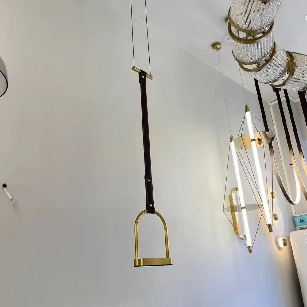 A minimalist black leather belt pendant light with polished brass horsebit design for decorbites art minimalist decor