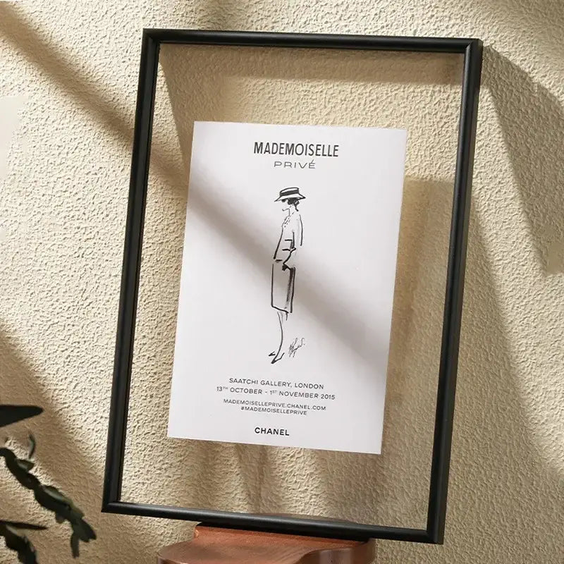 Black-framed minimalist hangable picture frame featuring chanel mademoiselle privé line drawing art on white paper