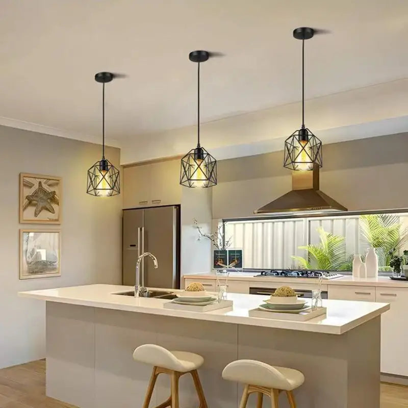 Three minimalist black metal geometric pendant lights with black finish hang above a kitchen island