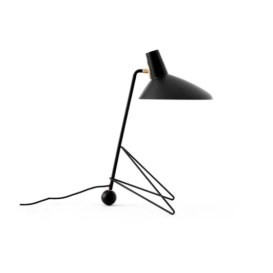 Minimalist black metal tripod desk lamp with angled shade for bedroom or office use in sleek design