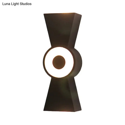 Minimalist black metal wall sconce with geometric bow silhouette and warm white light for bedroom use