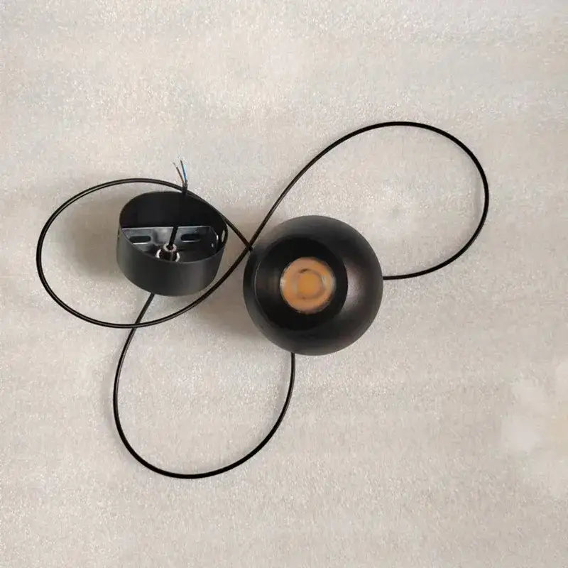 Minimalist black spherical pendant light with die-cast aluminum and acrylic lamp holder featuring visible led bulb