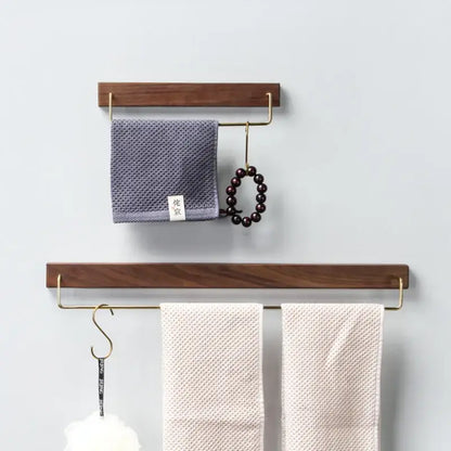 Minimalist black walnut wood towel rack 2 pack with brass accents holding gray and cream towels and a beaded bracelet