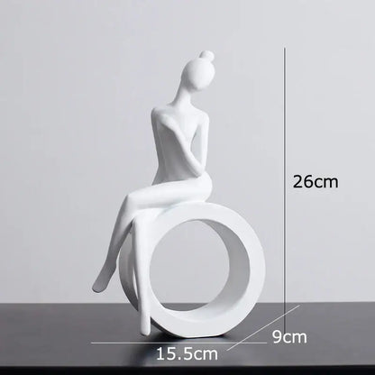 White ceramic abstract resin sculpture of seated woman with hair in bun on circular base for decorbites abstract decor