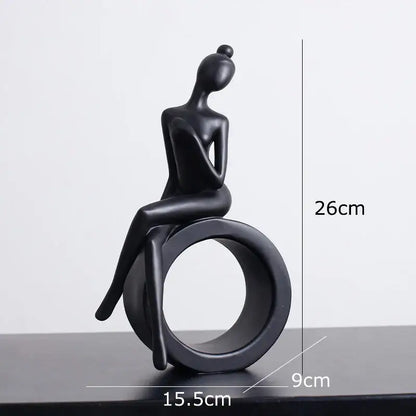 Minimalist black and white decorbites abstract resin sculpture of seated woman with bun on circular ring base for living room decor