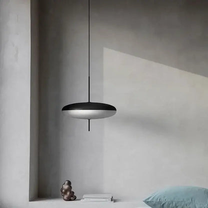 Minimalist black and white acrylic pendant light with a sleek disc-shaped design for dining room use
