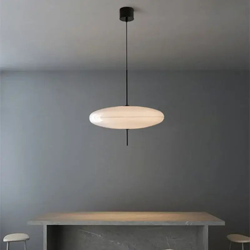 Minimalist black and white designer pendant light with oval frosted glass shade suspended by thin black cord for dining room decorbites designer pendant