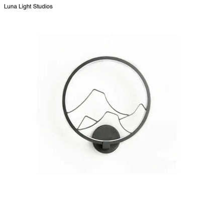 Black circular acrylic ring wall lamp with minimalist mountain silhouette design for bedroom use