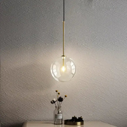 Minimalist brass and clear glass ball pendant light with warm illumination for dining room decorbites clear glass design