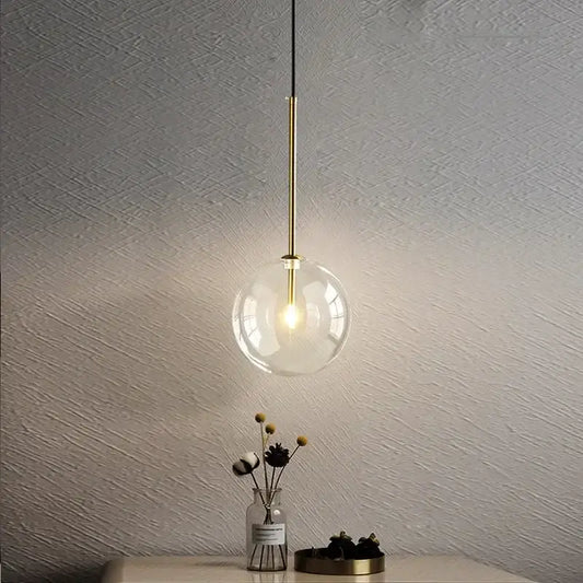 Minimalist brass and clear glass ball pendant light with warm illumination for dining room decorbites clear glass design