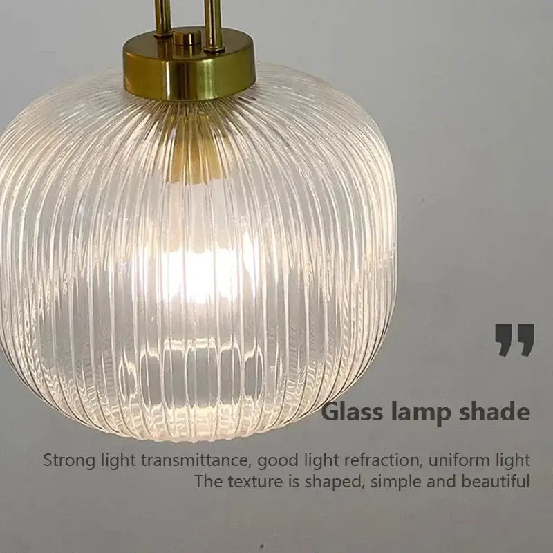 Minimalist pendant light with clear ribbed glass shade and brass-finished top for dining room cord pendant installation