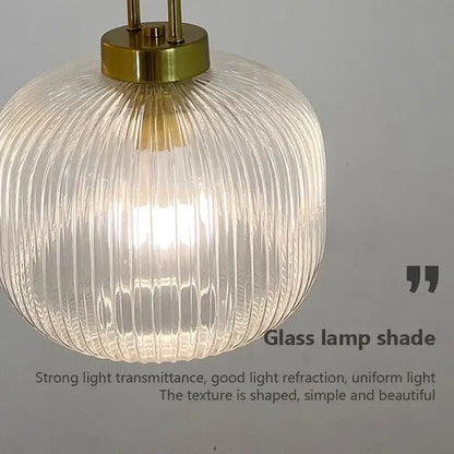 Minimalist pendant light with clear ribbed glass shade and brass-finished top for dining room cord pendant installation