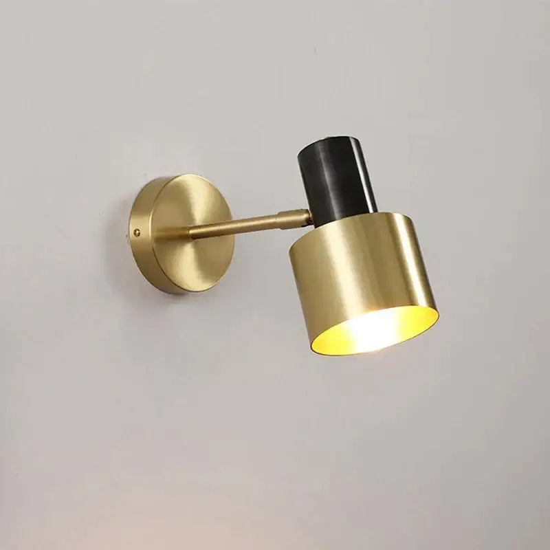 Minimalist brass and black iron wall lamp with warm glowing light for stylish bedroom decorbites iron wall lamp