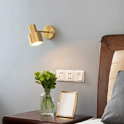 Minimalist gold-toned wall lamp with cylindrical shade and adjustable arm made of brass and black iron for decorbites iron wall lamp