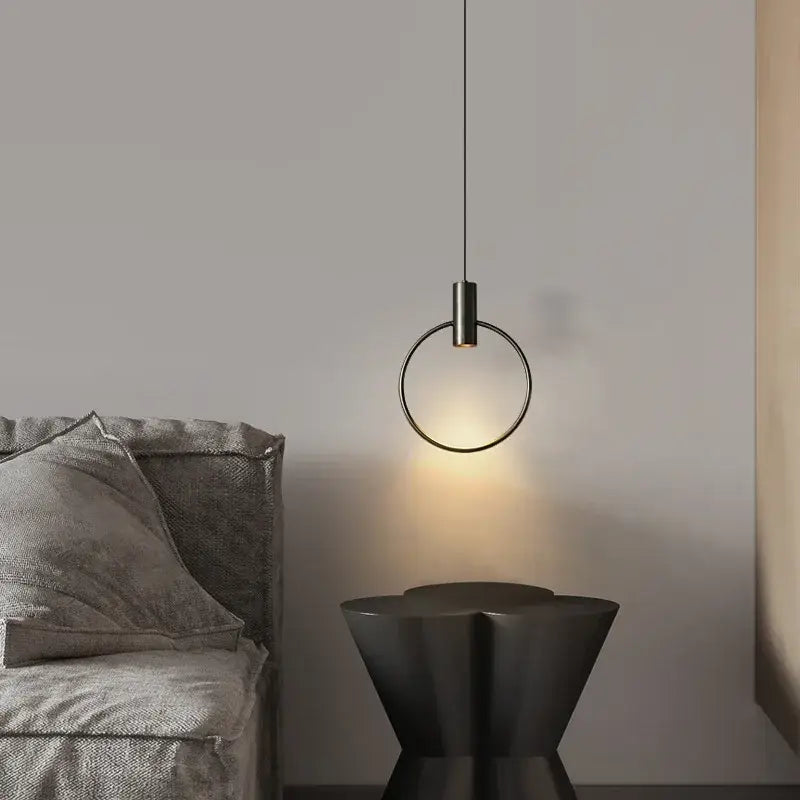 Minimalist brass ring chandelier with black metal cylindrical pendant light and warm ambient glow for bedroom decorbites brass ring