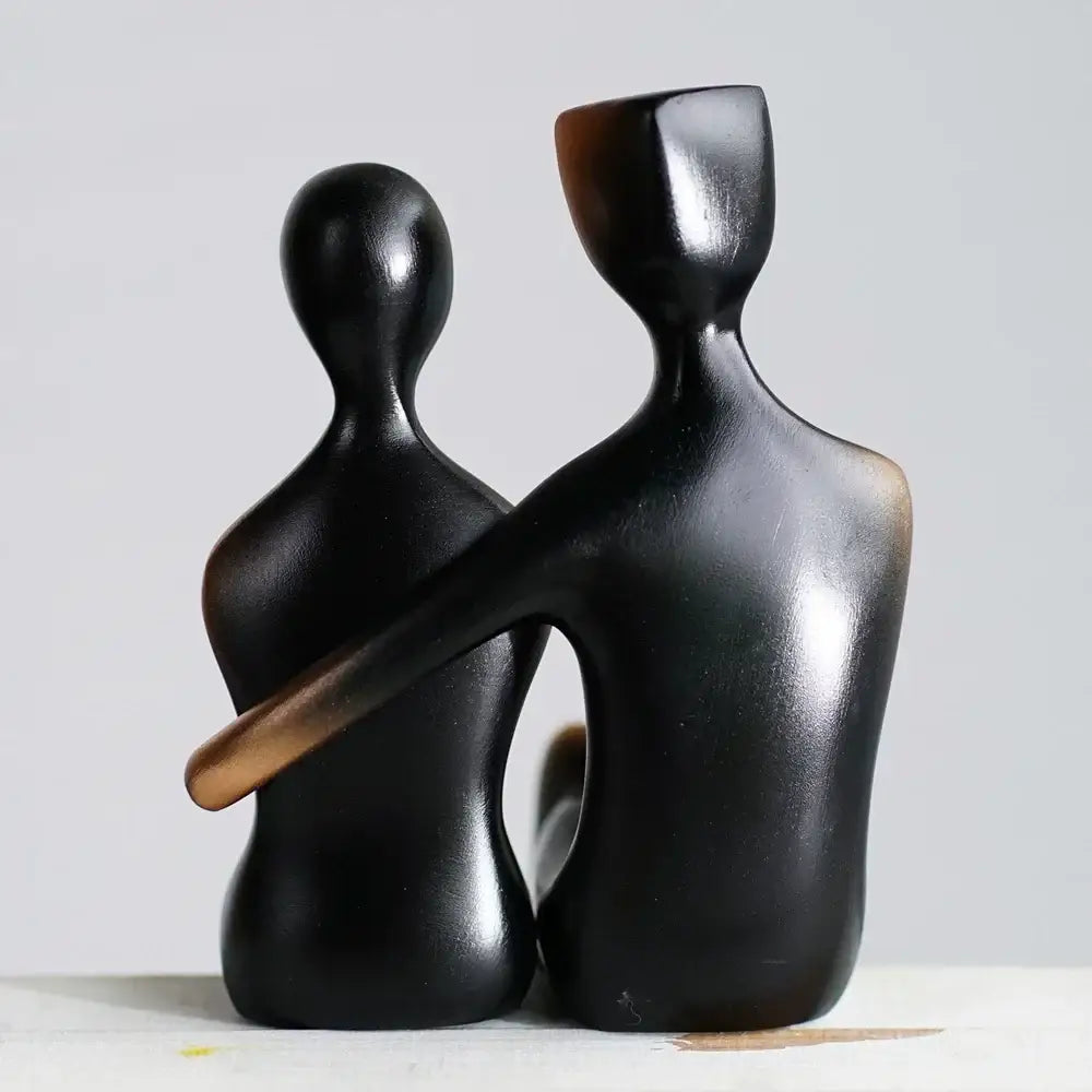 Black glossy resin couple sculptures featuring two abstract human forms embracing for minimalist bedroom decorbites elegant resin decor