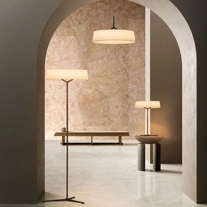 Minimalist bronze italian design floor lamp with cylindrical off-white fabric shade and slender black metal frame by decorbites italian design