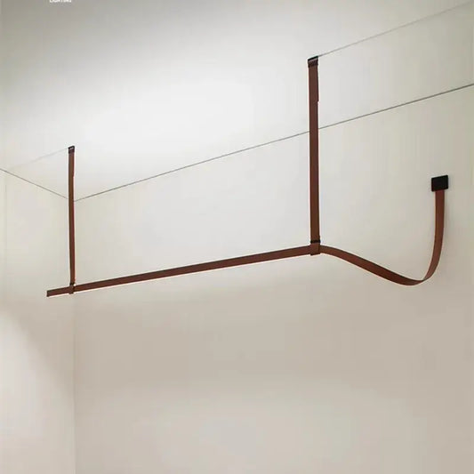 Minimalist brown leather wall-mounted clothes drying rack with decorbites belt design for bedroom decor and pendant light settings