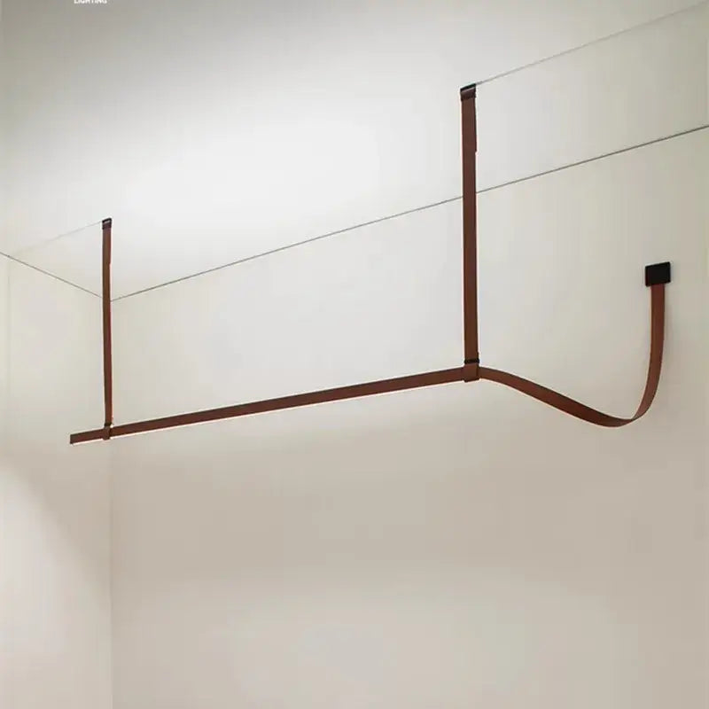 Minimalist brown leather wall-mounted clothes drying rack with decorbites belt design for bedroom decor and pendant light settings